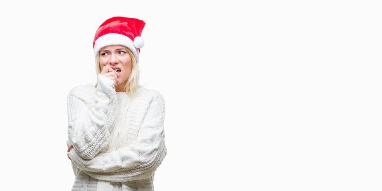 Blonde Woman Wearing Christmas Hat Over Isolated Background Looking Stressed And Nervous With Hands On Mouth Biting Nails.jpg