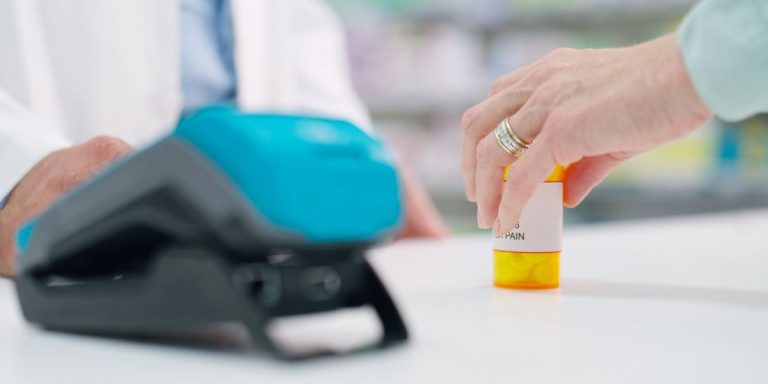 Customer Purchasing A Bottle Of Pills In A Pharmacy.jpg