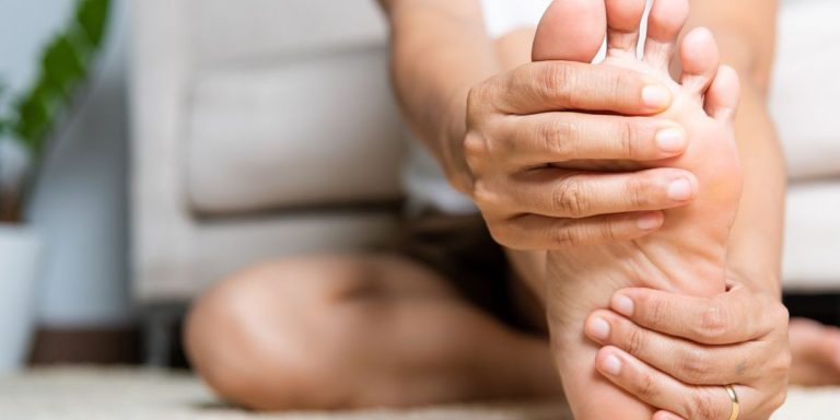 Woman Feeling Pain In Her Foot At Home.jpg