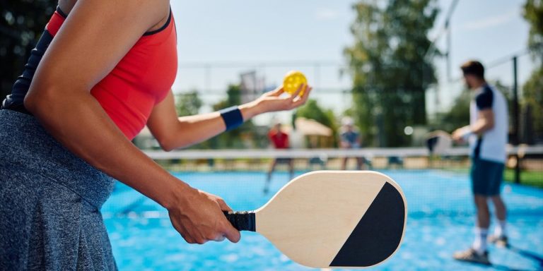 Woman Serving The Ball While Playing Mixed Doubles In Pickleball.jpg