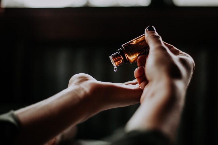 Person Holding Amber Glass Bottle.jpg