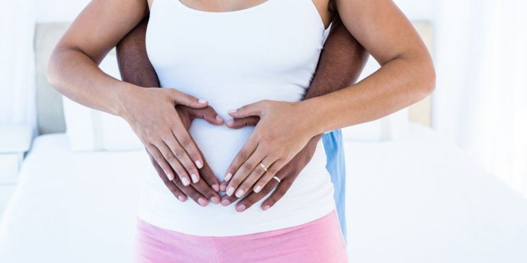 Midsection Of Couple Hands Making Heart Shape On Belly.jpg