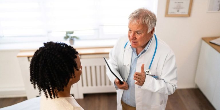 Female Patient Of African American Ethnicity Having An Annual Medical Check Up With A Senior Male Caucasian Doctor.jpg