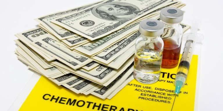 Hundred Dollar Bills And Drug Vials Syringe On Top Of A Chemotherapy Transport Bag.jpg