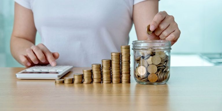 Woman Counting Coins With Calculator.jpg