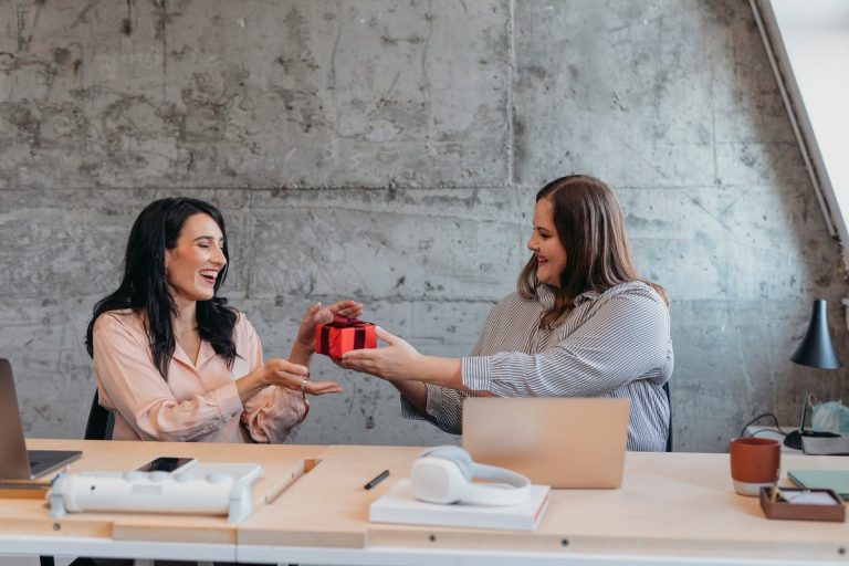 Female Gives Friend Wrapped Gift In An Office Setting. F2vfsb0.jpg