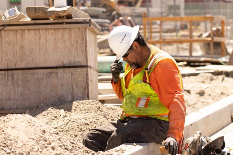 Worker Adjusts His Helmet On A Construction Site.jpg