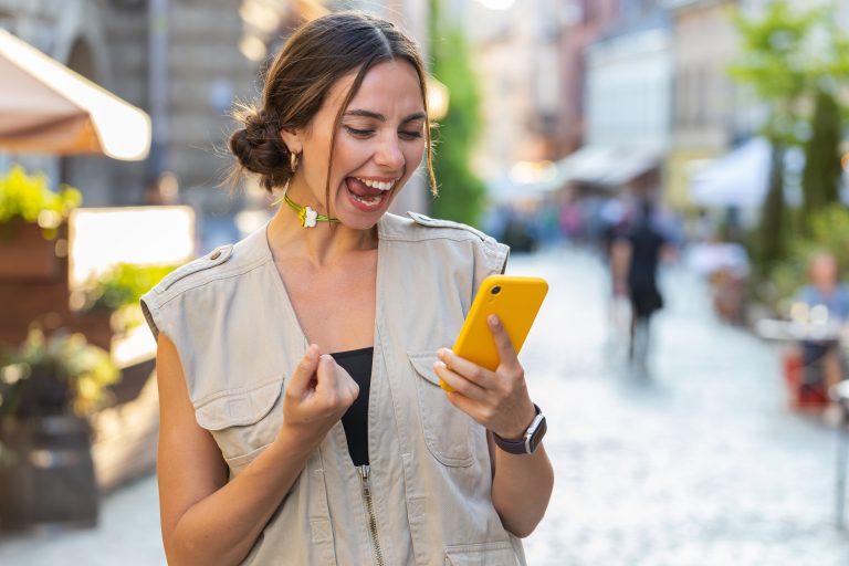 Person Reacting Joyfully To Something On A Smartphone.jpg